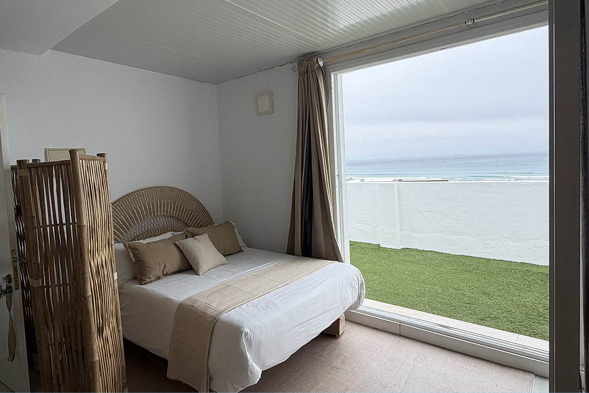 Dormitorio con cama doble y vistas al mar desde el apartamento Infinity en Tarifa.